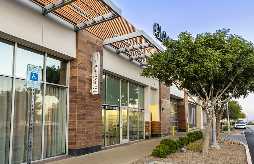 Glam House 2026 (2) Exterior of a modern commercial building with large windows, a Chai House sign, and a reserved accessible parking sign. Trees and landscaping line the storefront, with Sparkles Beauty Bar also located nearby for added convenience.